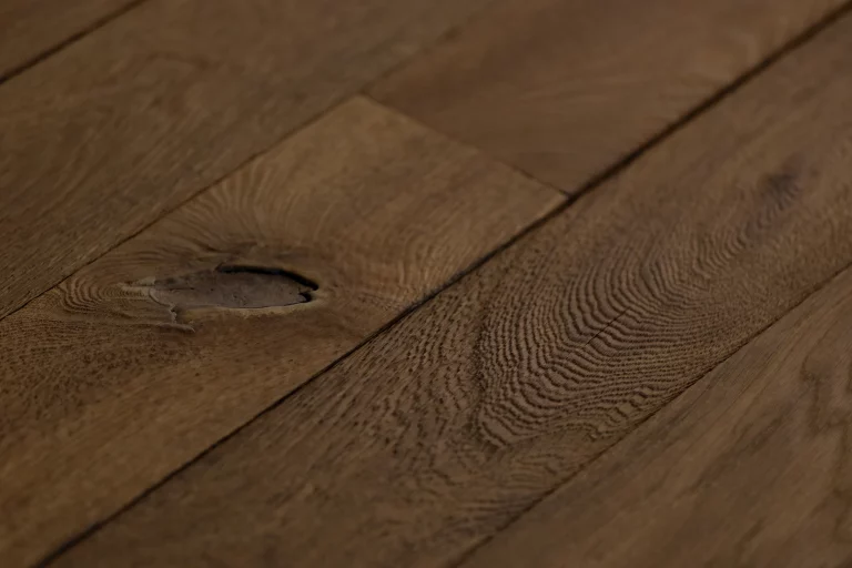 Détail d’un parquet Arbony en chêne vieilli à la main, avec nœud et relief naturel du bois.