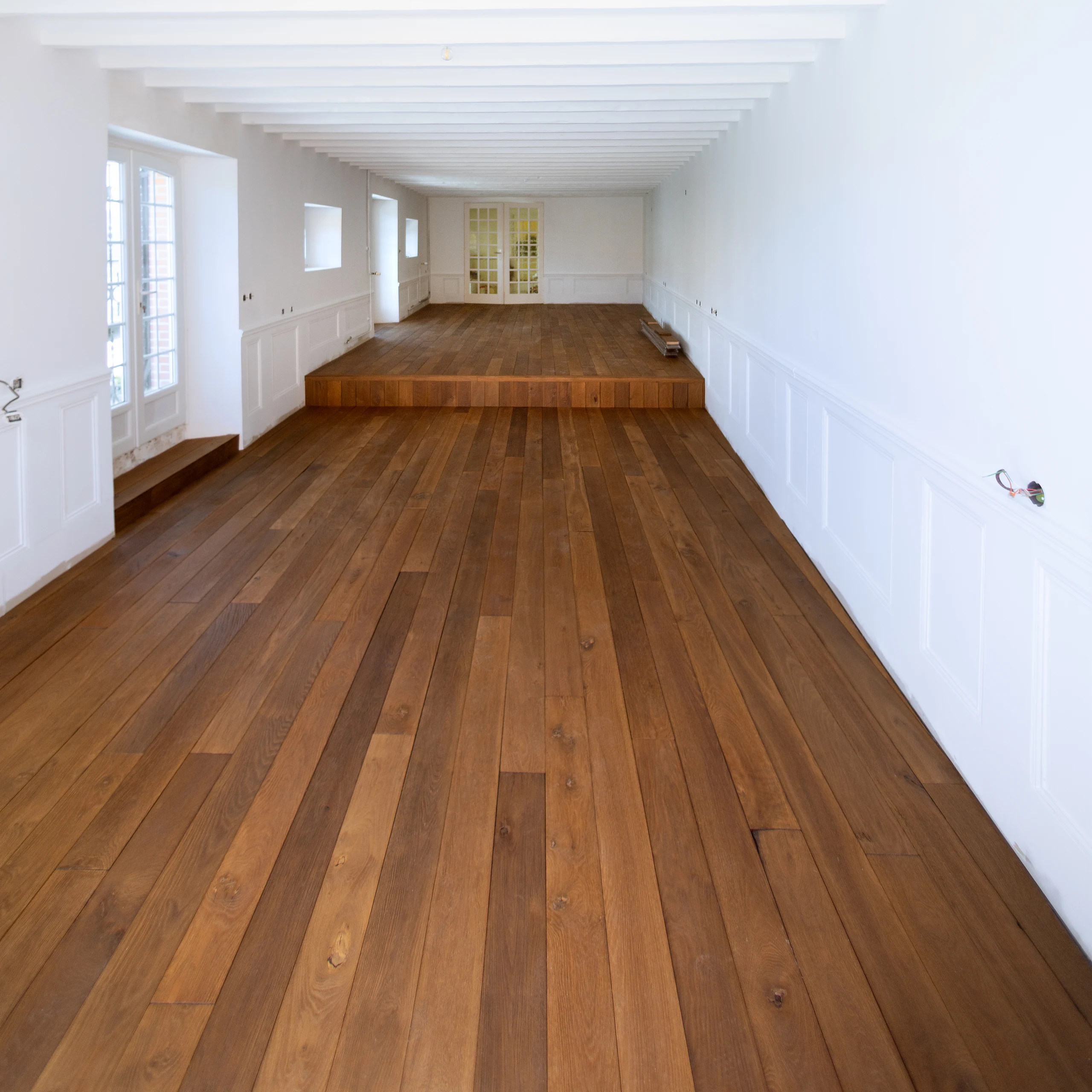 Projection d’un intérieur contemporain avec parquet Arbony en chêne vieilli, canapé en lin et mobilier moderne.